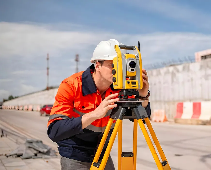 geodet zaměřuje stavbu silnice pomocí totální stanice